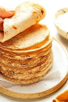 a stack of tortillas sitting on top of a white plate