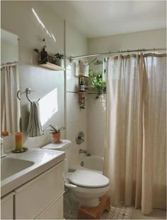 a bathroom with a toilet, sink and shower curtain in it's center area