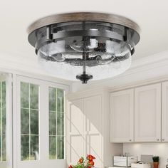 a kitchen with white cabinets and an overhead fan