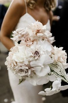 a bride holding a bouquet of white flowers