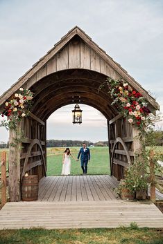 a bride and groom are walking into the barn