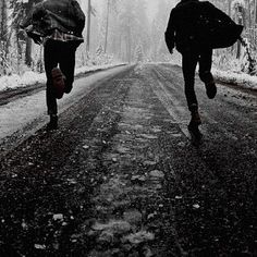 two people walking down a road in the snow