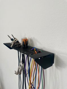 several wires are attached to the wall and hanging from it's side with hooks