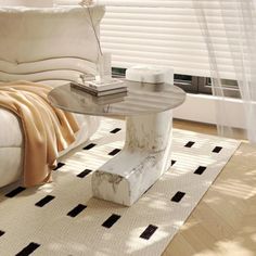 a living room with a white couch and coffee table on top of carpeted flooring