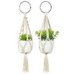 two white hanging planters with plants in them