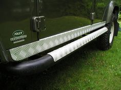 a green jeep parked on top of a lush green field