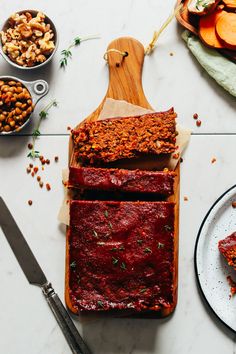 slices of meatloaf sitting on top of a cutting board next to other food