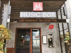 an entrance to a music box with red lips on the door and sign above it