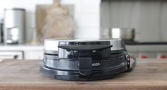 a close up of a food processor on a wooden table in front of a stove