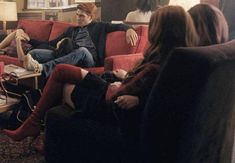 three people sitting on a couch in a living room