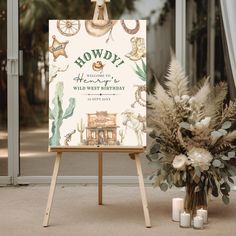 an easel with a sign and flowers in front of it