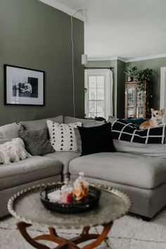 a living room filled with lots of furniture and pillows on top of a white rug