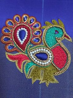 a close up of a peacock on a blue cloth with gold and red trimmings