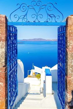 an open doorway leading to the ocean with blue doors and railings on either side