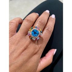 Beautiful to say the Least!  This Ring has a magnificent Cushion Cut Blue Topaz that weighs 4.33 carats and is surrounded by 16 Round Cut Multi Colored Sapphires that weigh 2.91 carats and 38 Round Cut Diamonds that weigh 0.50 Carats (Clarity: SI, Color: F). The total carat weight of the ring is 7.74 carats. This unique beauty is set in 14 Karat Rose Gold and weighs approximately 8.7 grams. It is a ring size 7  Exact dimensions for this item are unknown. Please reach out in the seller Q&A for an Rose Gold Cocktail, Colored Sapphires, Gold Cocktail Ring, Gold Cocktail, Unique Beauty, Sapphire Diamond, Ring Size 7, Cocktail Ring, Round Cut Diamond