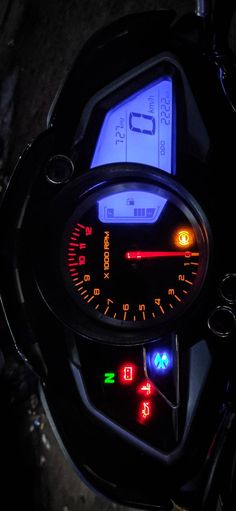 the speedometer is lit up in red, white and blue on a motorbike