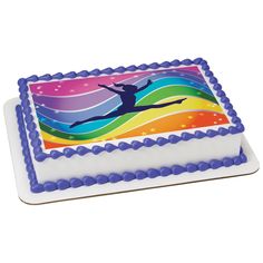 a birthday cake with a person jumping in the air and rainbow stripes on it's side