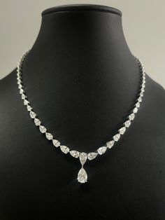 Diese Halskette verfügt über eine atemberaubende Anordnung von birnenförmigen Diamanten, die sorgfältig in einer durchgehenden Linie angeordnet sind, wodurch ein klassisches und elegantes Design entsteht. Die Brillanten sind größenmäßig abgestuft und vereinen sich in einer größeren birnenförmigen Raute, die mittig einen hängenden Tropfen bildet. Jeder Diamant ist in eine Krappenfassung gesetzt, was die Brillanz und das Feuer der Steine maximiert. Die Halskette ist wahrscheinlich in Weißgold gefe Pear Shaped Necklace, Diamond Drop Necklace, Diamond Necklace Set, Continuous Line, Pear Shaped Diamond, Drop Necklace, Lab Diamonds, Pear Shaped, Prong Setting