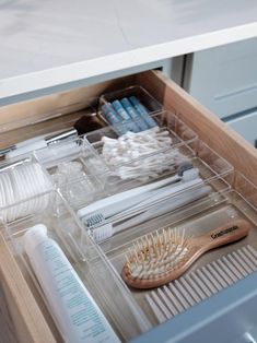 an open drawer with toothbrushes, combs and other items