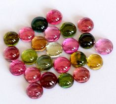 many different colored stones on a white surface