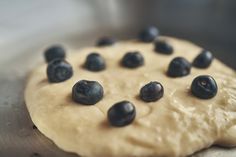 a doughnut with blueberries on it sitting in the middle of some floured dough