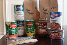 some food is sitting on a table next to two brown paper bags with writing on them