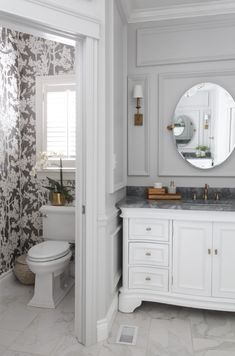 a bathroom with a toilet, sink and mirror in it's center piece is shown