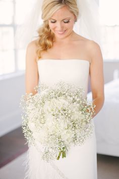 a woman in a wedding dress holding a bouquet of flowers