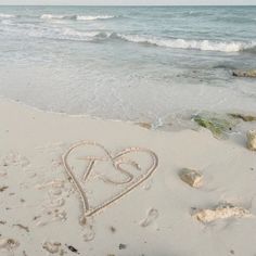 a heart drawn in the sand at the beach