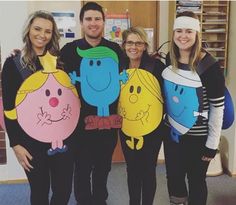 four people dressed up as cartoon characters posing for a photo in front of a classroom