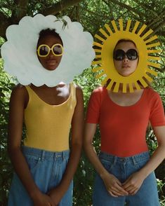 two women wearing sunflowers and sunglasses standing next to each other