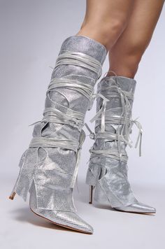 Keep it more than cute in The AZALEA WANG Cordial Silver Rhinestone Boot. This unique knee-high boot features a slim stiletto heel, a pointed toe silhouette, and a fold-over shaft. Complete with glitter textile upper, rhinestone-embellished detailing throughout, interlocking panel overlays, and an ultra-strappy tie up design. (all measurements approximate from size 7.5): - Glitter Textile Upper - Square Toe - Chunky Heel - 4” Heel Height - 14.25” Shaft - 16.5” Shaft Opening Circumference - 13” Calf Circumference - 31” Strap Length - Imported Product ID: 375454