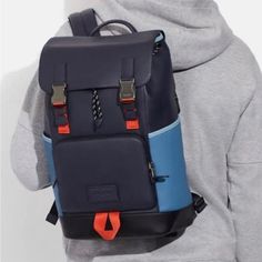 a person wearing a gray hoodie with a blue and black backpack on their back