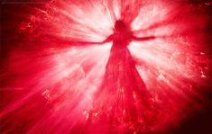 a person standing in the middle of a red and white light with their arms outstretched