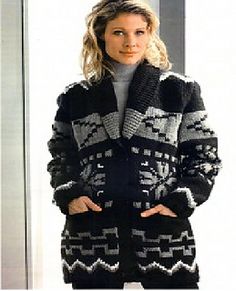 a woman standing in front of a door wearing a black and white knitted coat