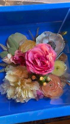 a bunch of flowers sitting in a blue container