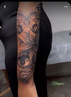 a woman's arm with an owl and flower tattoo on the left side of her body