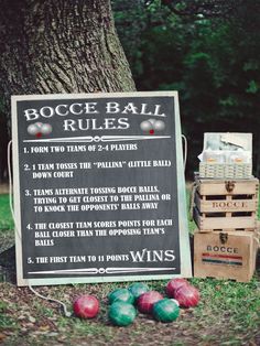 a sign that is sitting in the grass next to some balls and boxes on the ground