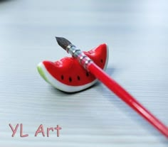 a watermelon shaped object with a paintbrush sticking out of it's tip