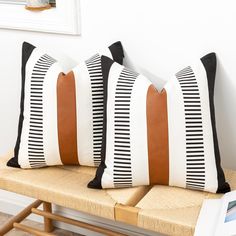 two black and white striped pillows on a bench