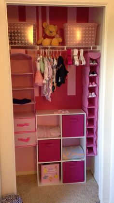 a closet with pink bins and shelves filled with baby's clothing, toys and other items