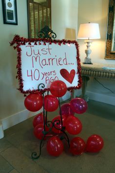 a sign that says just married 40 years ago with red balloons in front of it