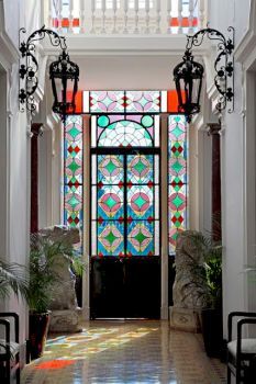 an entry way with stained glass windows and potted plants