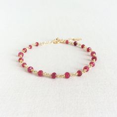 "This is a Ruby bracelet made of 3mm Ruby beads and sterling silver gold plated wire. The total length for this July Birthstone bracelet is 7.5\" including 2\" extension chain. This Ruby bracelet is simple and elegant. The dainty gold bracelet is great to layer with other tiny gold bracelet. Measurement: 3mm Ruby 6\" - 7.5\" long Gift Wrap: Please add this item to your shopping cart if you would like it to be gift wrapped. https://www.etsy.com/listing/217575192/gift-wrap-jewelry-gift-wrap-holida Elegant Charm Bracelet With Faceted Beads As Gift, Adjustable Dainty Ruby Jewelry, Dainty Adjustable Ruby Jewelry, Wire Wrapped Gold Bracelet As Gift, Faceted Yellow Gold Bracelets As Gifts, Elegant Charm Bracelet With Faceted Beads, Red Gemstone Dainty Bracelets, Gold Ruby Gemstone Beads Jewelry, Red Gemstone Dainty Bracelet