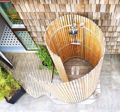 an aerial view of a wooden structure in the middle of a courtyard with potted plants