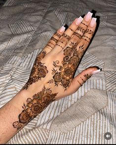 a woman's hand with henna tattoos on it