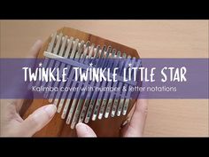 a person holding a wooden comb in their hand with the words twinkle twinkle little star on it