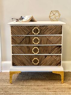 a white and gold chest of drawers with glasses on top