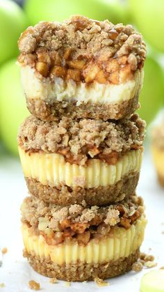 three cupcakes stacked on top of each other with apples in the back ground