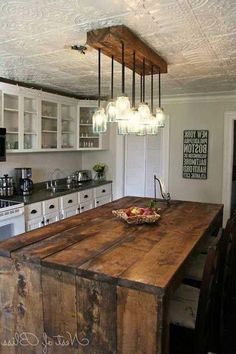 a kitchen with an island made out of wood and lights hanging from it's ceiling